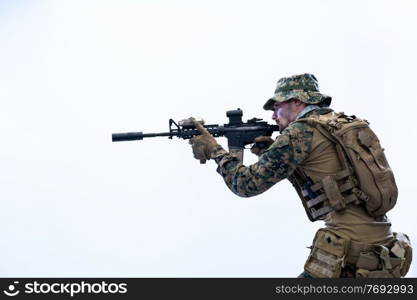 modern warfare american marines soldier in action while sneaking and aiming  on laseer sight optics  in combat position and  searching for target in battle