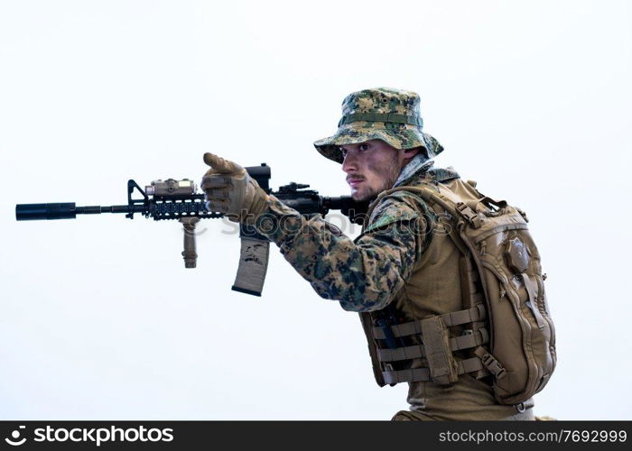 modern warfare american marines soldier in action while sneaking and aiming  on laseer sight optics  in combat position and  searching for target in battle