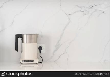 Modern white electric kettle on a white kitchen table. Modern white electric kettle