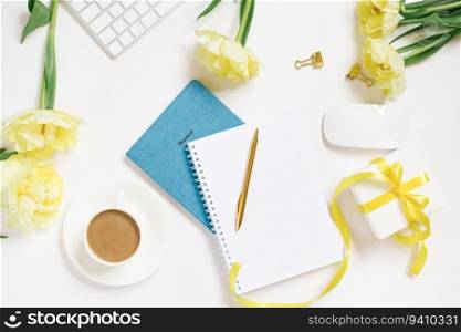 Modern white office desk table with a cup of coffee, computer keyboard, notebooks, pen, flowers and other accessories. Top view with a space to copy on a white background. Top view, flat lay.