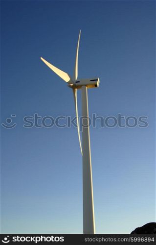 Modern white wind turbine or wind mill producing energy