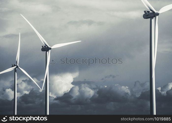 modern windmill on a sunny day and with idyllic moody clouds, closeup of the foreground, Energy concept black and white