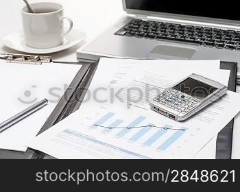 Modern workplace phone on business notepad office desk laptop