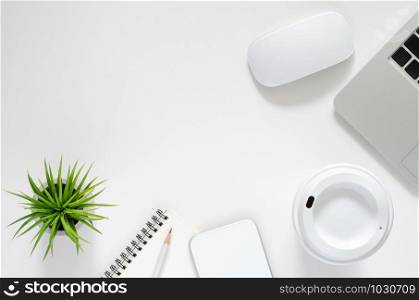 Modern workplace with laptop computer, wireless mouse, coffee cup, smartphone, notebook, pencil and Tillandsia air plant on white background. Top view, flat lay concept.