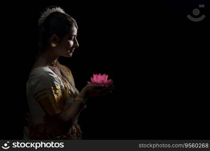 Mohiniattam dancer in Anjali mudra holding a Lotus flower in her hand