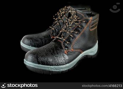 moist modern working boots isolated on a black background