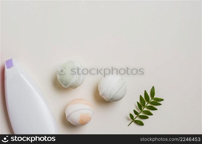 moisturizer bottle bath bombs leaves white background