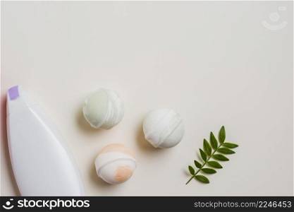 moisturizer bottle bath bombs leaves white background