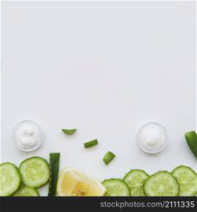 moisturizer cream container aloevera lemon cucumber slices white background
