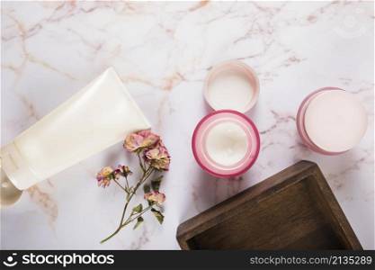 moisturizing cream with flowers marble background