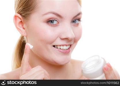 Moisturizing skin care, cosmetics, dermatology concept. Woman applying face cream with her finger, studio shot isolated. Woman applying face cream with her finger