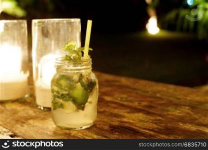 Mojito cocktail, glass of lemonade on wooden table