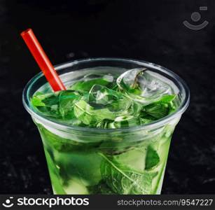 Mojito cocktail in a plastic glass with a tube