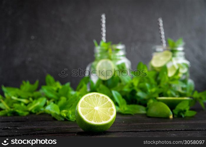 Mojito cocktail with lime and mint in highball glass on a black stone background Copy space.. Mojito cocktail with lime and mint in highball glass on a black stone background Copy space