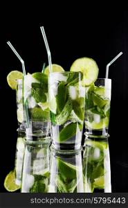Mojito cocktails with lime and mint on black background . Mojito cocktails