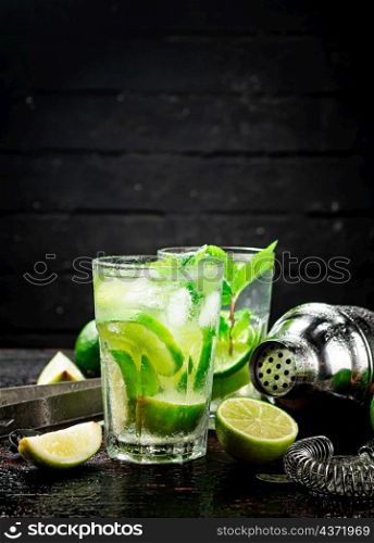 Mojito with lime and mint. On a black background. High quality photo. Mojito with lime and mint.