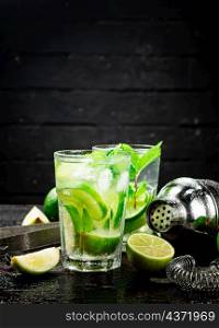 Mojito with lime and mint. On a black background. High quality photo. Mojito with lime and mint.