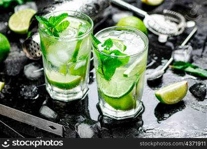 Mojito with mint and ice. On a black damp background. High quality photo. Mojito with mint and ice.