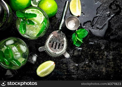 Mojito with mint and ice. On a black damp background. High quality photo. Mojito with mint and ice.