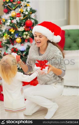 Mom and baby girl changing Christmas presents