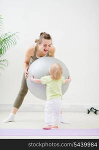 Mom and baby playing with fitness ball