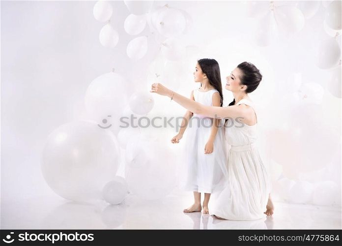 Mom and cute daughter playing balloons