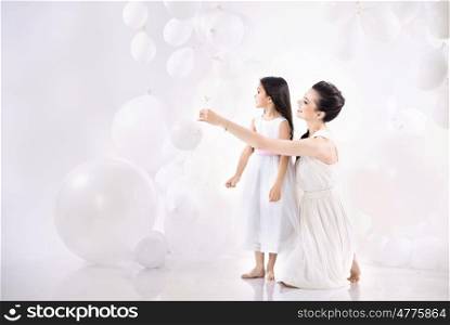 Mom and cute daughter playing balloons