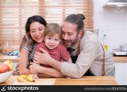 Mom and dad in the kitchen of the house with their small children. Have a good time making dinner together.