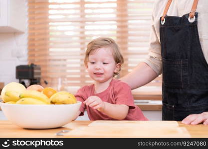 Mom and dad in the kitchen of the house with their small children. Have a good time making dinner together.