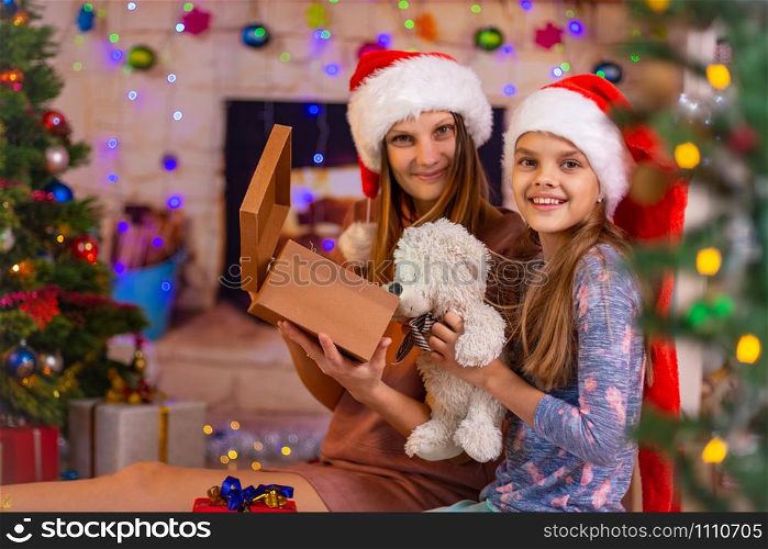 Mom and daughter opened the Christmas box with a gift and looked into the frame