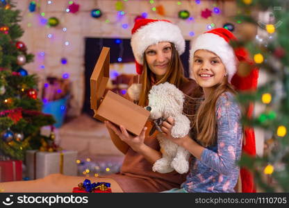 Mom and daughter opened the Christmas box with a gift and looked into the frame