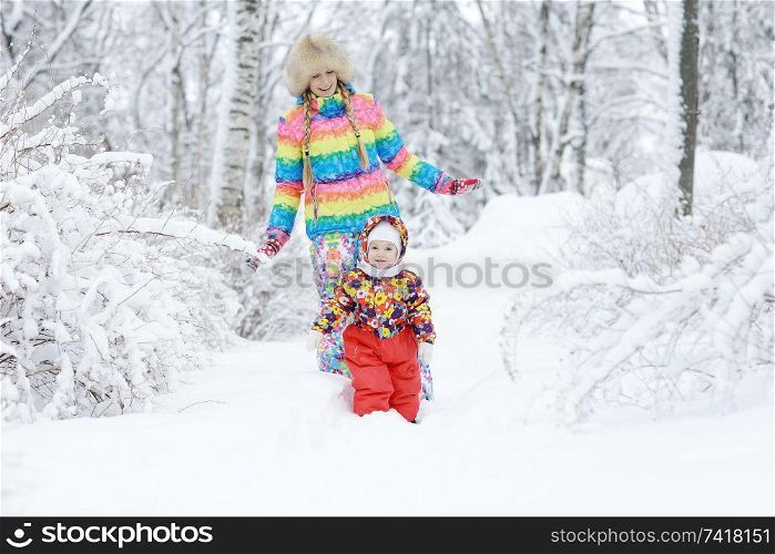 mom and little daughter on a winter walk in the park white