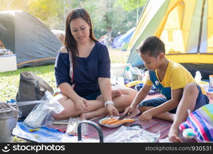 Mom and Son camping in forest.