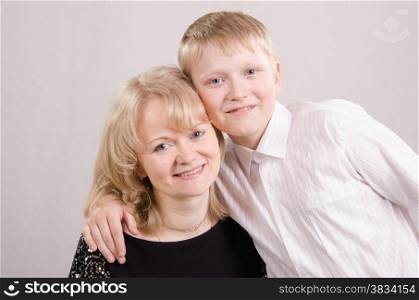 Mom and teen son hugging looks in the picture