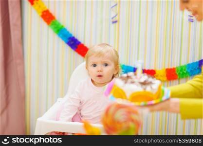 Mom carries cake for surprised baby