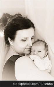 Mom cuddle a newborn baby. Mother holds the kid on hands. Black and white