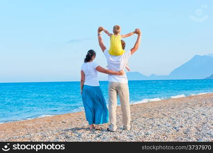 mom dad and son watching the sea and mountains