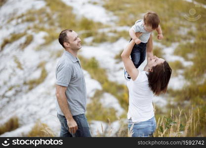 Mom, dad hugging daughter in the mountains enjoy and look at nature. Young family spending time together on vacation, outdoors. The concept of family summer holiday. Mother&rsquo;s, father&rsquo;s, baby&rsquo;s day.. Mom, dad hugging son in the sand mountains enjoy and look at nature. Young family spending time together on vacation, outdoors. The concept of family summer holiday. Mother&rsquo;s, father&rsquo;s, baby&rsquo;s day.