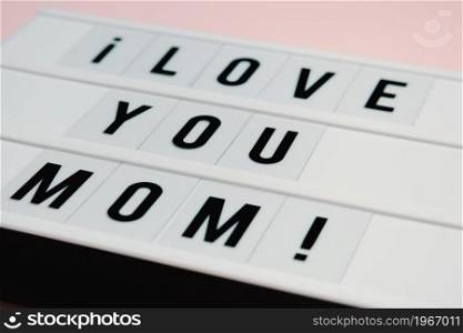 Mom day sign over a pastel pink background says love you mom, love concept, minimal, copy space, style design