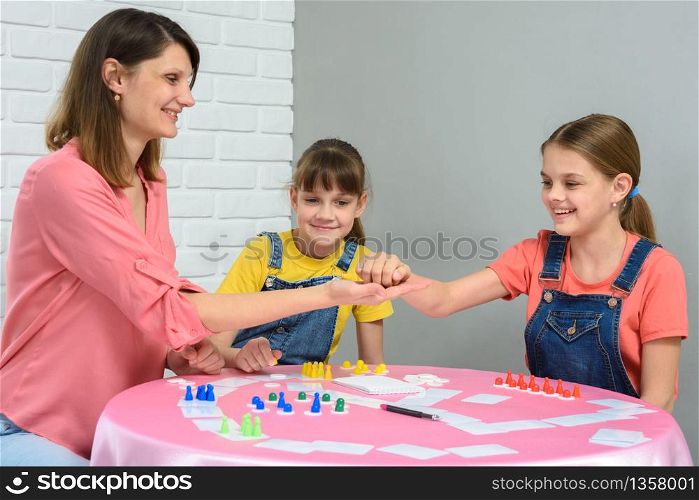 Mom gives cubes to daughter playing board games