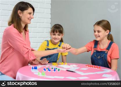 Mom gives cubes to daughter playing board games
