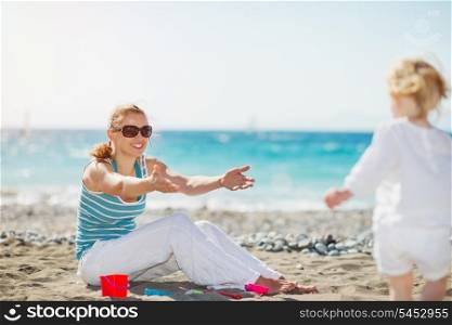 Mom playing with baby on beach