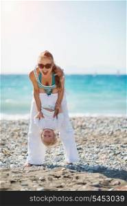Mom playing with baby on beach