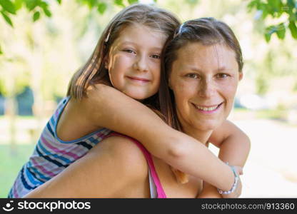 Mom playing with her child outdoors in the park in a sunny day