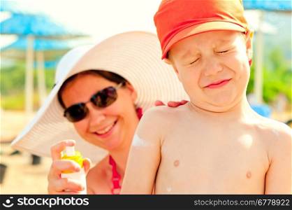 Mom puts on the baby&#39;s skin lotion for sun protection