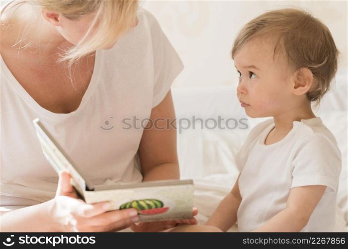 mom reading baby bed