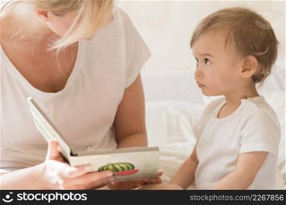 mom reading baby bed