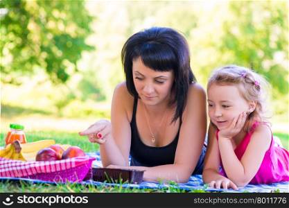Mom showing her daughter at a picnic fruit