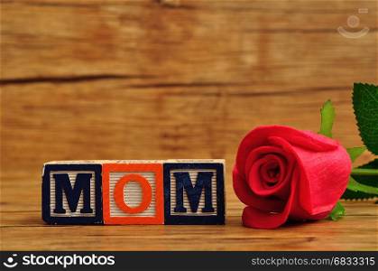 Mom spelled with colorful alphabet blocks and a red rose
