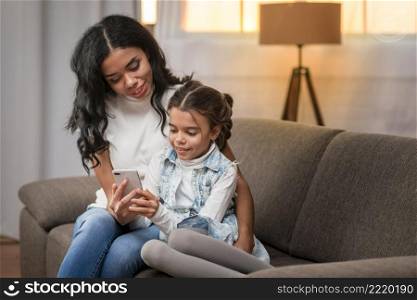 mom teaching daughter use mobile